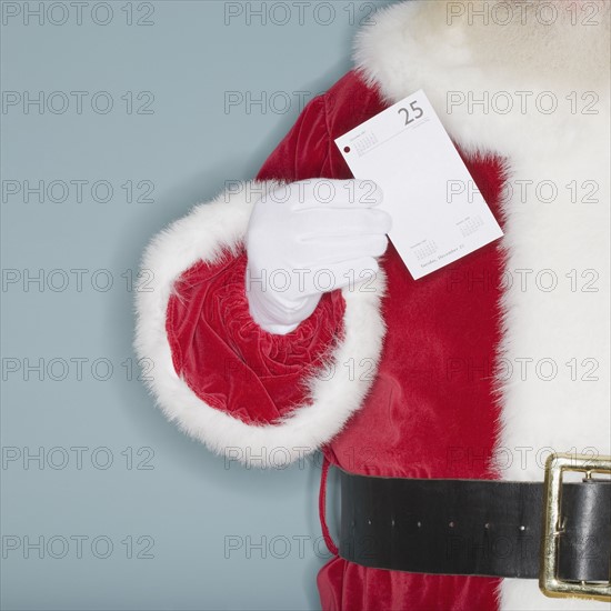 Santa Claus holding desk calendar page.