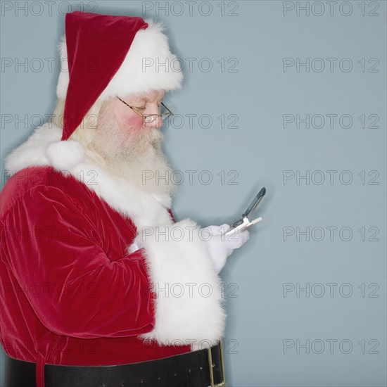 Santa Claus looking at cell phone.