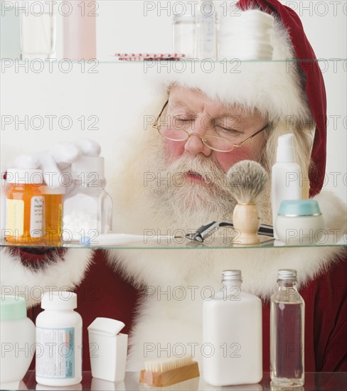 Santa Claus looking in medicine cabinet.