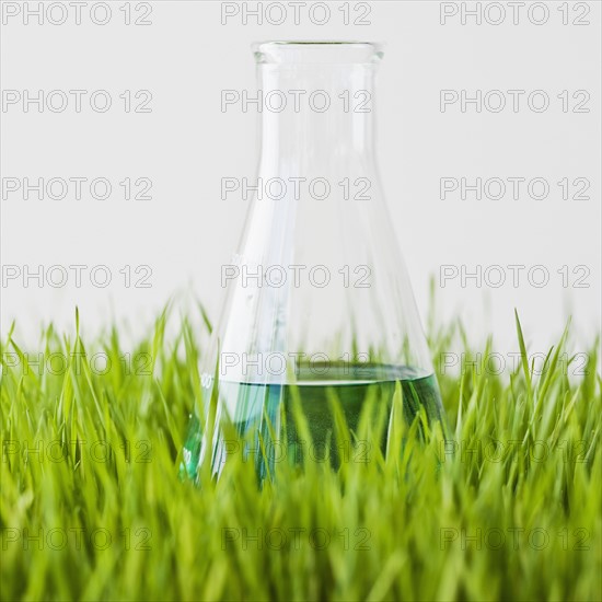 Beaker with liquid in grass.