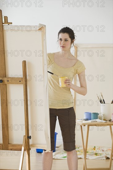 Woman painting on easel.