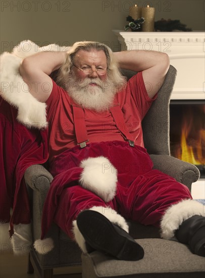 Santa Claus relaxing in armchair.