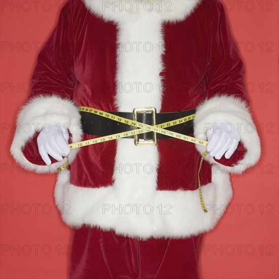 Santa Claus measuring waist with tape measure.