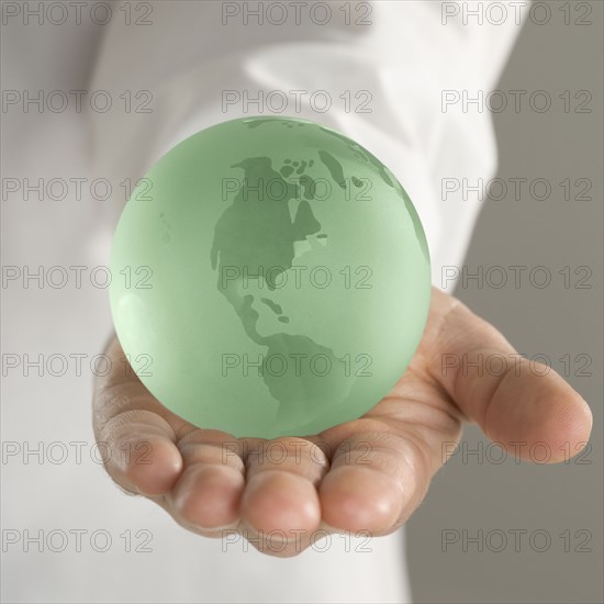 Hand holding globe.