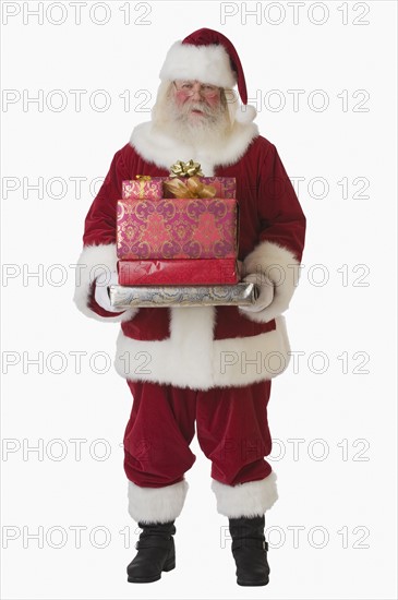 Santa Claus holding stack of gifts.