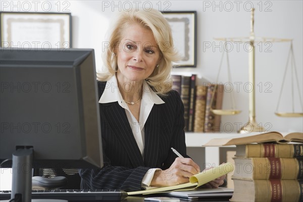 Businesswoman writing on notepad.