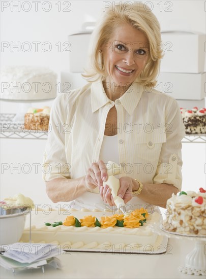 Female baker decorating cake.