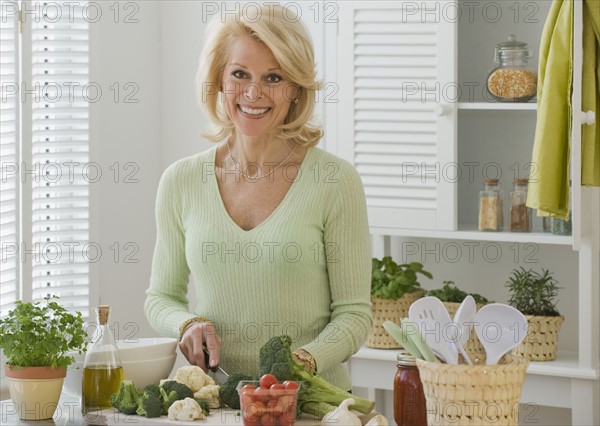 Senior woman chopping vegetables.