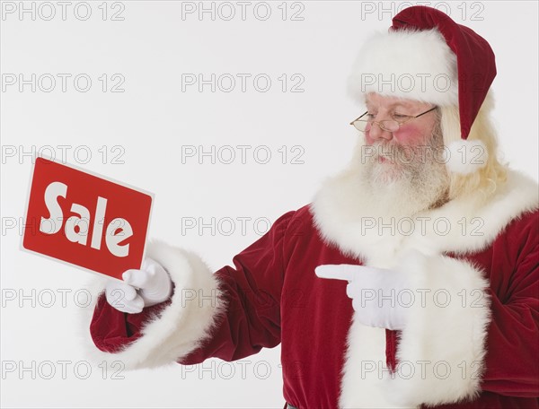 Santa Claus holding Sale sign.