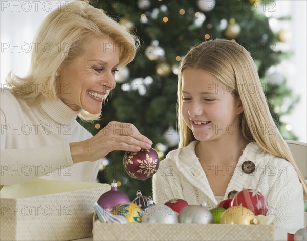 Grandmother and granddaughter looking at Christmas ornaments.