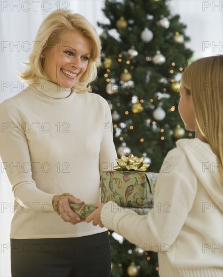 Grandmother and granddaughter holding Christmas gifts.