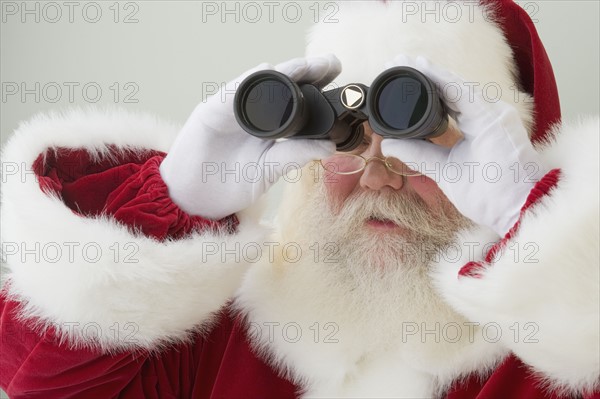 Santa Claus looking through binoculars.