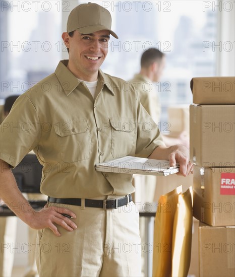 Delivery man standing next to packages.