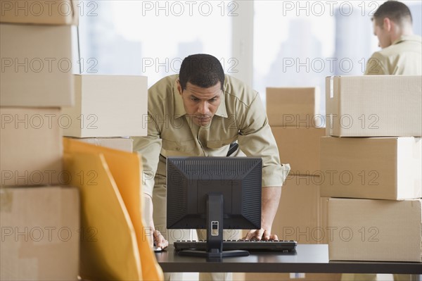 African delivery man looking at computer.