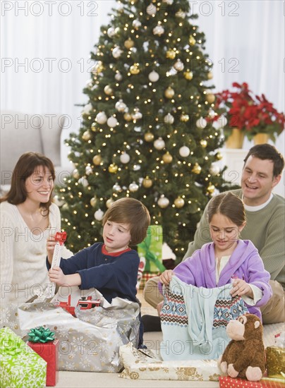 Siblings opening Christmas gifts.