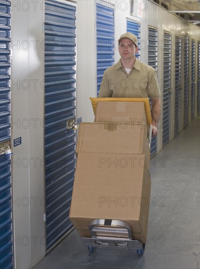 Delivery man pushing stack of packages.