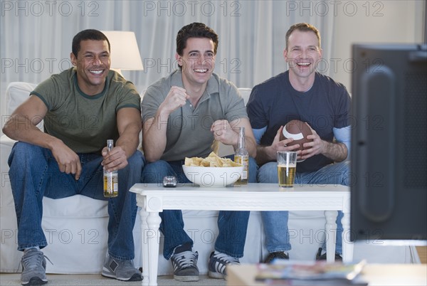 Multi-ethnic men watching sports on television.