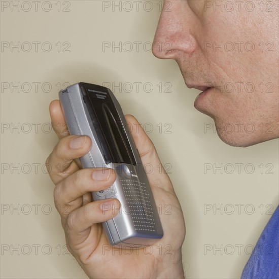 Man talking into voice recorder.