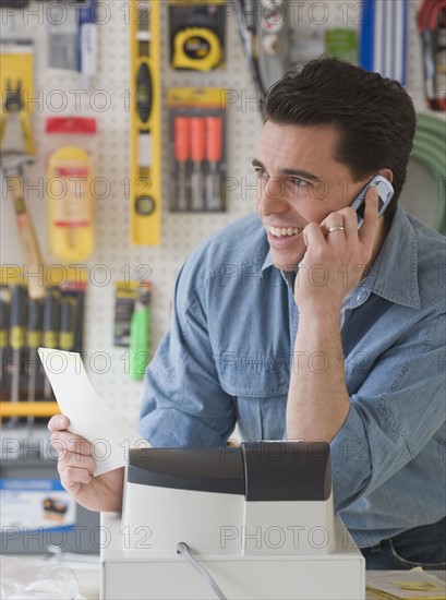 Sales clerk talking on telephone in hardware store.