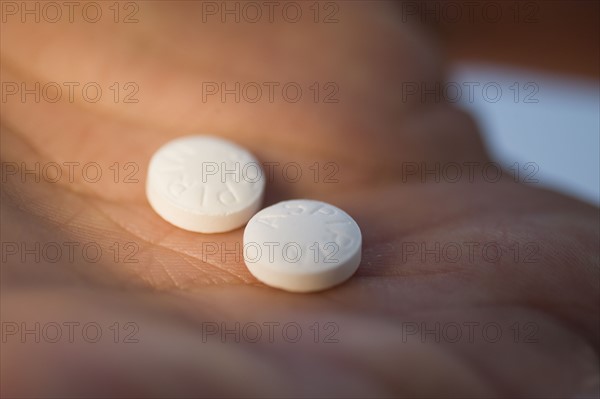 Close up of medication in man’s hand.