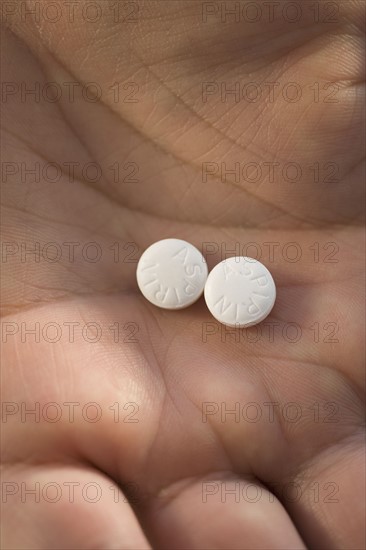 Close up of medication in man’s hand.