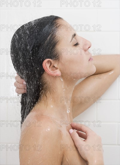 Woman standing under shower.