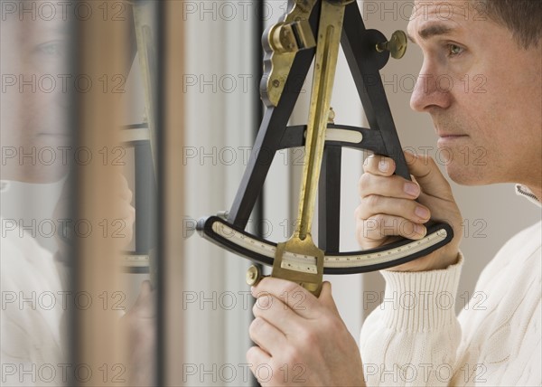 Man measuring angle with sextant.