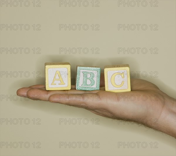 Man holding ABC blocks.
