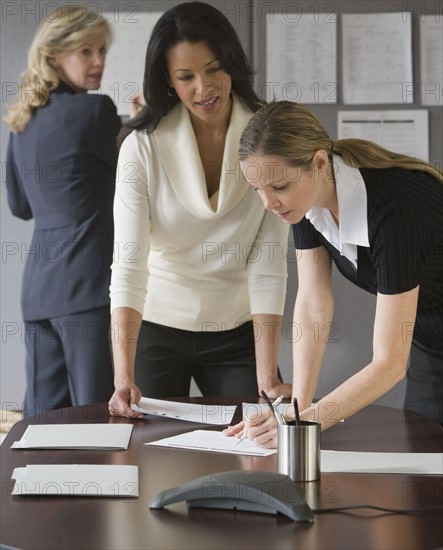 Multi-ethnic businesswomen looking at paperwork.