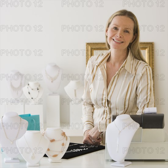 Woman behind counter at jewelry store.