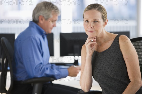 Businesswoman with businessman in background.