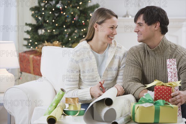 Couple wrapping Christmas gifts.