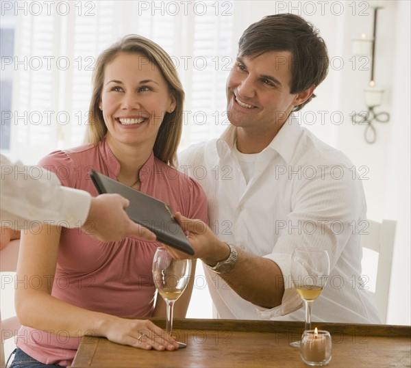 Couple paying at restaurant.