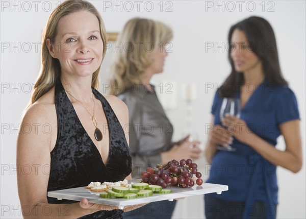 Woman carrying tray of hors d’ouevers.