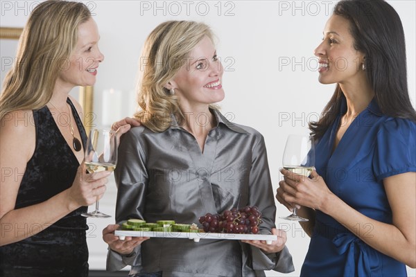 Woman offering tray of hors d’ouevers.