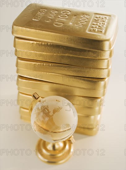 Globe next to stack of gold bars.