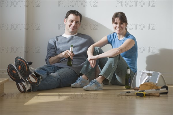 Couple drinking beer on floor.