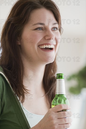 Woman holding bottle of beer.