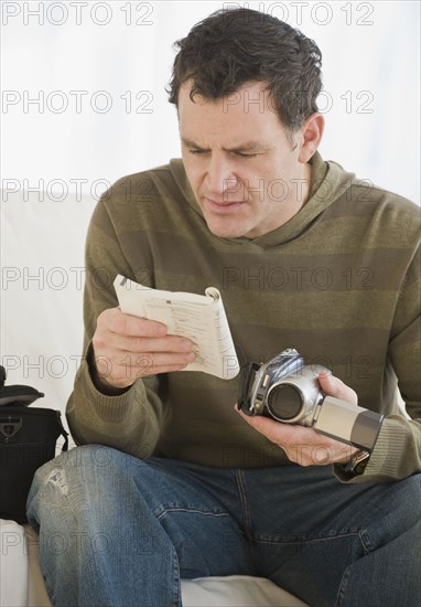 Man reading camera manual.