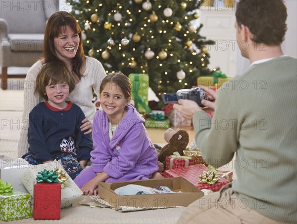 Father video recording family on Christmas.