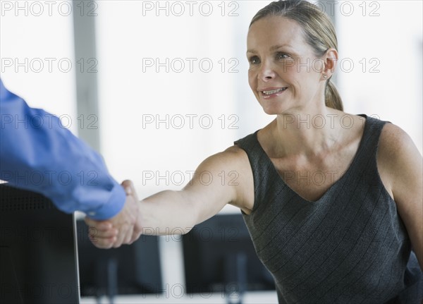 Businesswoman shaking coworker’s hand.