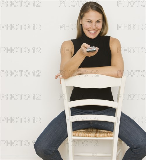 Woman pointing remote control.