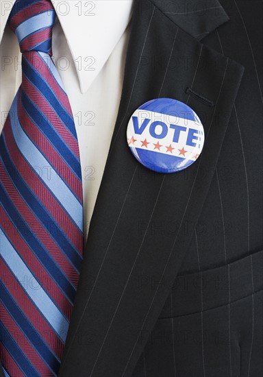 Vote pin on man’s lapel.