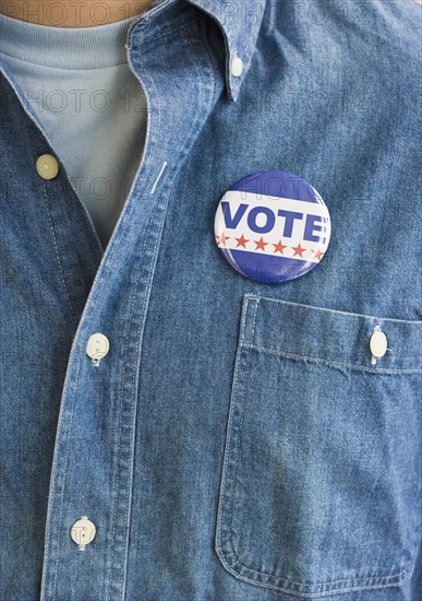 Vote pin on man’s shirt.