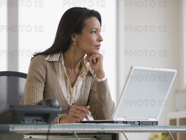 African businesswoman next to laptop.