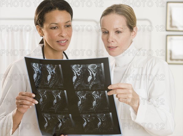 Multi-ethnic female doctors looking at x-ray.