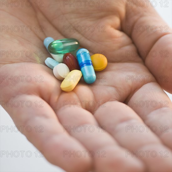 Close up of medication in man’s hand.