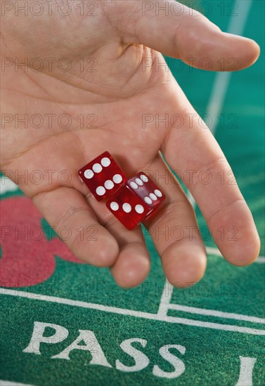 Close up of dice in man’s hand.