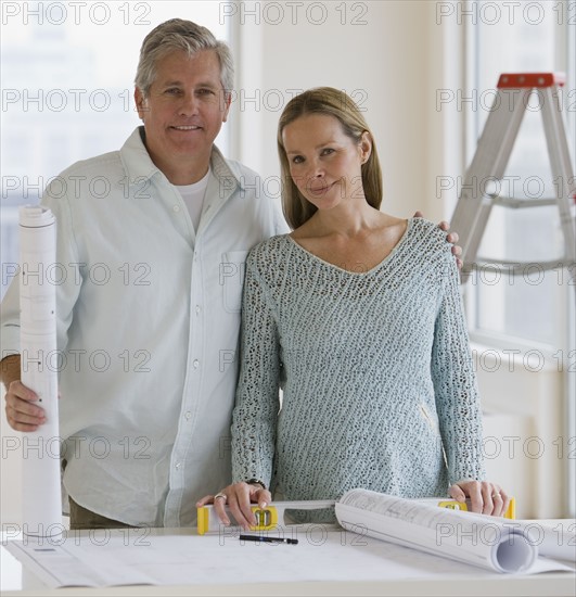 Couple next to blueprints.