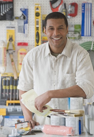 African sales clerk behind counter at hardware store.